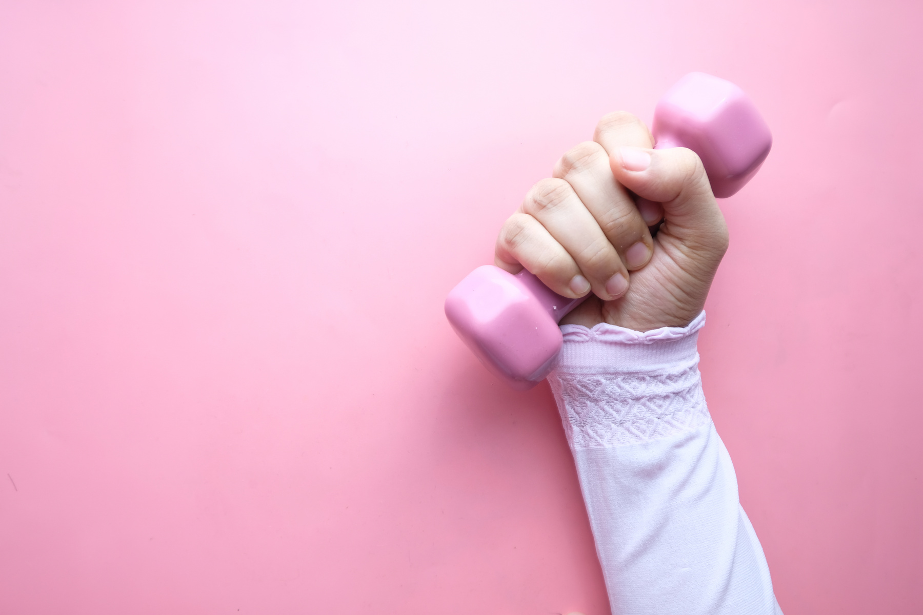 Top View of Woman Hand Holding Pink Dumbbell.